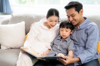 parent supporting phonics and early reading at home with young child