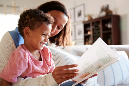 child reading aloud from book to improve reading fluency at home
