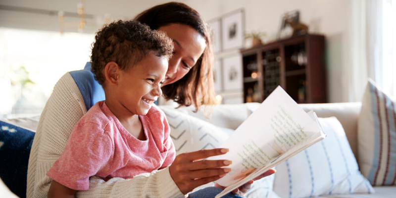 child reading aloud from book to improve reading fluency at home